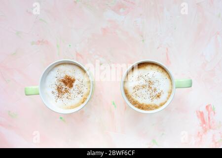Two cups of latte coffee on light pink background Stock Photo