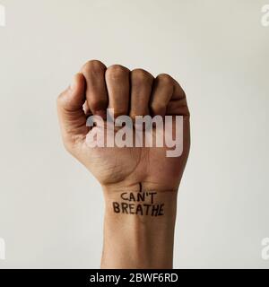 closeup of the raised fist of a man with the text I cant breathe in his wrist, as it is used as slogan in the George Floyd protests in response to pol Stock Photo