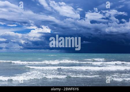 Upcoming storm in Jesolo, Italy with heavy clouds, blue atmosphere and rough sea Stock Photo