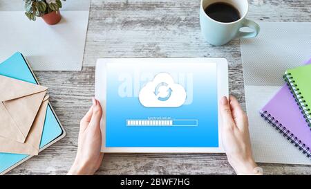 Cloud synchronization progress bar on tablet screen. Data storage and protection. Technology and internet concept Stock Photo