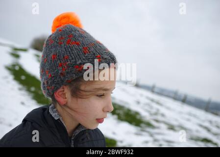 Ten year old girl portrait in winter woolen bobble hat. Stock Photo