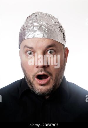 paranoid man wearing tin foil hat in shock - conspiracy theaory Stock Photo