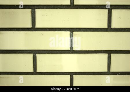 Texture of a yellow brick wall background in the countryside, rough blocks of stone, brick masonry horizontal color technology architecture wallpaper. Stock Photo