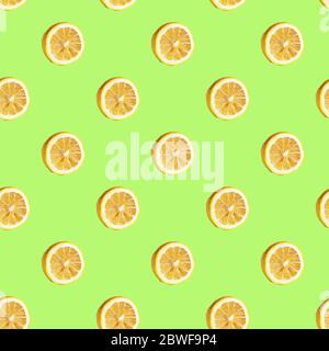 Seamless pattern with lemon halves on a green background. Minimal isometric texture. Use for blackboard printing on fabric. View from above. Stock Photo