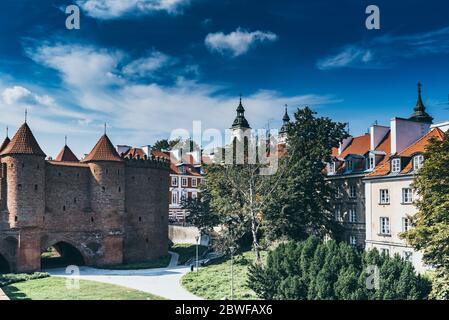 Warsaw, Poland summer view of Barbican or Barbakan wall and old town houses with green trees and blue sky Stock Photo