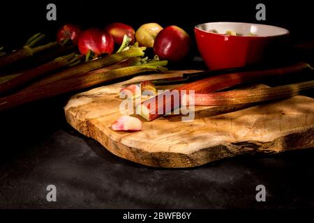 Fresh rhubarb and apples on cutting board. Stock Photo