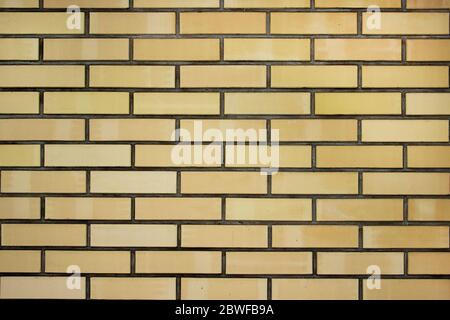 Texture of a yellow brick wall background in the countryside, rough blocks of stone, brick masonry horizontal color technology architecture wallpaper. Stock Photo