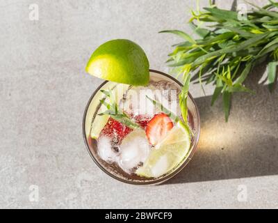 refreshing summer cocktail drink lemonade with ice, strawberries, lime and tarragon in a glass Stock Photo