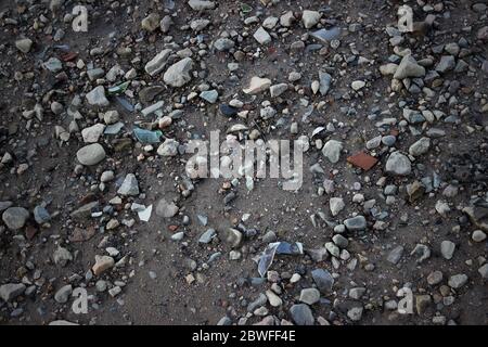 Broken glass, sea glass and beach debris scattered on the sand. Shells and stones at the beach. Garbage from broken glass bottles on the sand beach. T Stock Photo