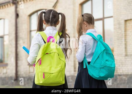 Study and spread knowledge. Little children carry heavy backpacks. Knowledge day. Back to school. Education and study. Knowledge skills. Private teaching. September 1. School time. Knowledge matters. Stock Photo