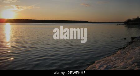 Evening sunrise on a choppy river wind early spring landscape. Sunset in the river with reflex. Stock Photo
