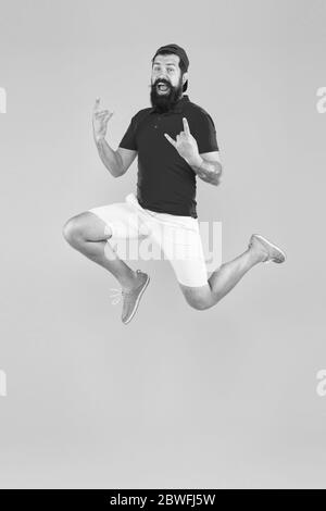 Energy charge. Healthy guy feeling good. Inspired concept. Always in motion. Enjoying active lifestyle. Happy guy jumping. Active bearded man in motion yellow background. Active and energetic hipster. Stock Photo