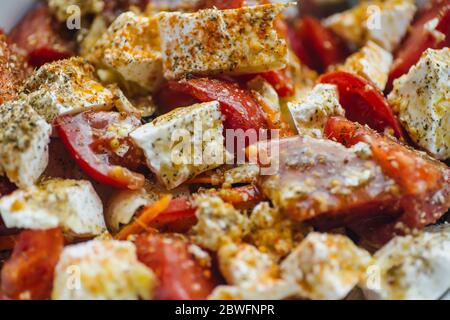 Salad with fresh tomatoes, feta cheese, olive oil and spices. Delicious light summer vegetable salad for lunch. Stock Photo