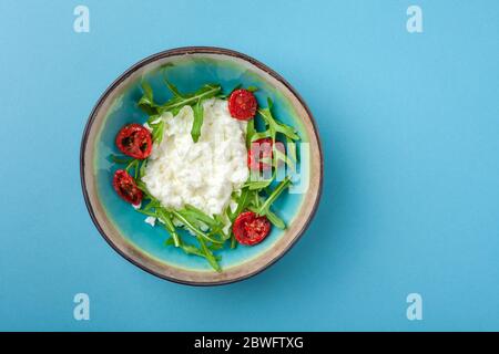 Breakfast bowl with eggs, scrambled egg on blue background Stock Photo
