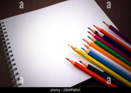 School notebook, Art Sketchpad Colored Pencils on brown background Stock Photo
