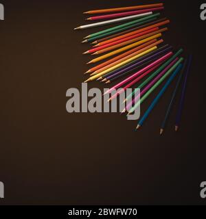 colour pencils on brown background, back to school concept. School accessories Stock Photo