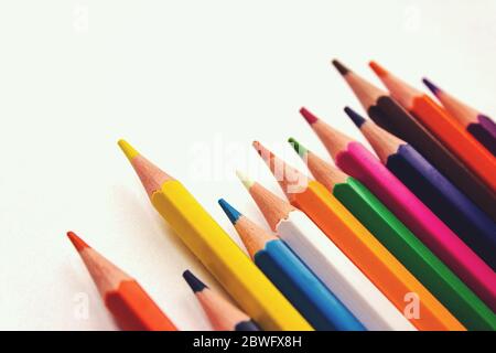 School notebook, Colored pencils in row on white background Stock Photo