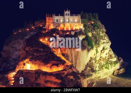 Tropea, Italy - September 6, 2019: The view on the Sanctuary of Santa Maria dell'Isola church with night lights. Night colorful illumination of Tropea Stock Photo