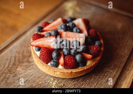 Tartlet with fruit on a wooden board Stock Photo