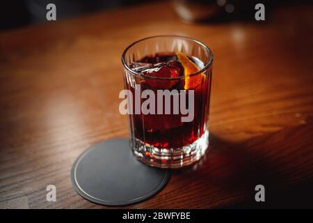 Negroni in a faceted glass on a wooden table