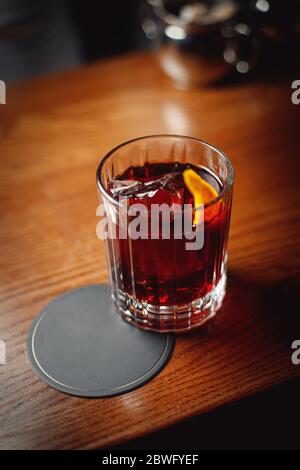 Negroni in a faceted glass on a wooden table