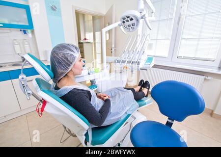 Female patient waiting for dental treatment in a dental chair. Dental Hygiene and Health conceptual image. Stock Photo