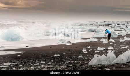 Unrecognized photographer capturing the ice chunks from the vatnajokull glacier during sunset in Iceland Stock Photo