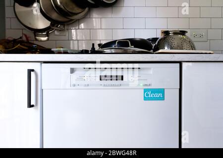 Dishwasher with clean magnet and pans drying on kitchen counter Stock Photo
