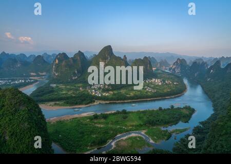 Shot of a Li river meandering through the beautiful green, lush and dense karst mountain landscape in Yangshuo, as seen from Xianggong Hill viewpoint, Stock Photo