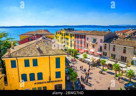 Sirmione, Italy, September 11, 2019: aerial panoramic view of historical centre pedestrian street Castle square piazza Castello, multicolored colorful buildings with red tiled roofs and Garda lake Stock Photo