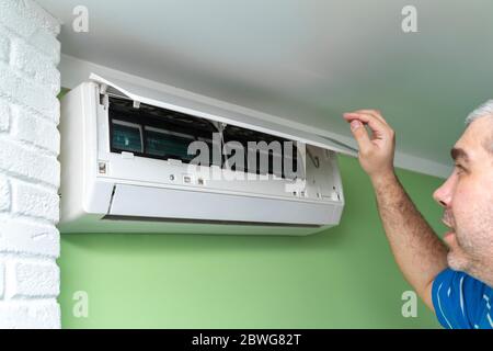Male technician repairing and reading air conditioners. Opening the lid and repair diagnostics Stock Photo