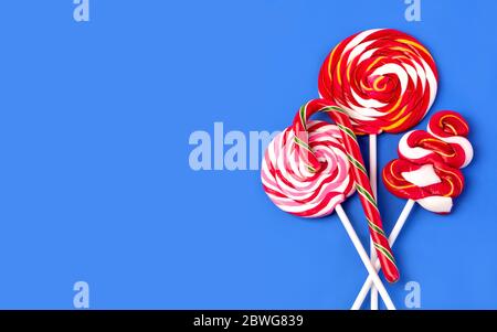 Colorful lollipop on blue background. Flat lay. Minimal concept Stock Photo