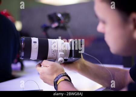 Moscow, Russia - October 04, 2019: men holds new camera sony alpha a7 iii 3 with lens sony 70-200 3,28-4,92. soft focus, side view Stock Photo