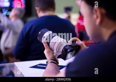 Moscow, Russia - October 04, 2019: men holds new camera sony alpha a7 iii 3 with lens sony 70-200 3,28-4,92. soft focus, side view Stock Photo