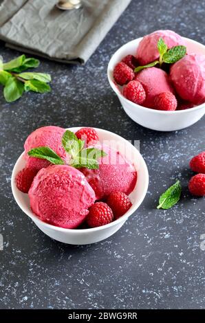 Raspberry ice cream in bowl on stone background, close up view Stock Photo