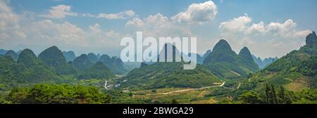 Wide panoramic view of the beautiful green, lush, tropical and dense karst mountain peaks and landscape in Yangshuo, Guangxi Province, China Stock Photo