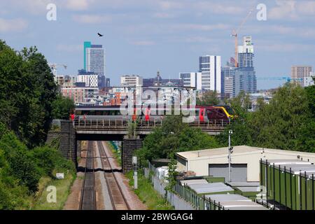 A rail class 221 Super Voyager train, operated by Cross Country, passes in front of Leeds skyline Stock Photo