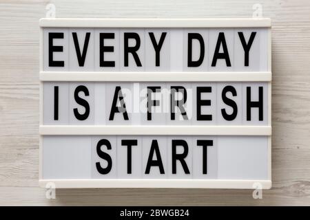 'Every day is a fresh start' words on a modern board on a white wooden background, top view. Overhead, from above, flat lay. Stock Photo