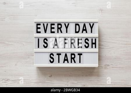 'Every day is a fresh start' words on a lightbox on a white wooden surface, top view. Overhead, from above, flat lay. Stock Photo