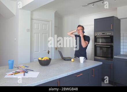 Man working from home in kitchen Stock Photo