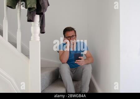 Man struggling with depression sitting on stairs Stock Photo