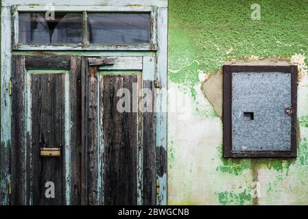 Grunge old vintage doors and damaged green painted wall Stock Photo