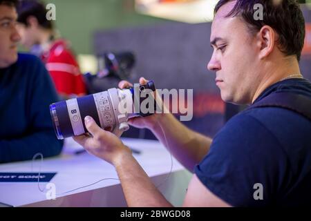 Moscow, Russia - October 04, 2019: men holds new camera sony alpha a7 iii 3 with lens sony 70-200 3,28-4,92. soft focus, side view Stock Photo