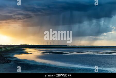 dramatic rain storm over lake at sunset in summer Stock Photo