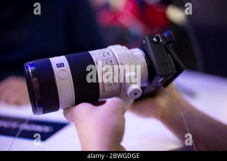 Moscow, Russia - October 04, 2019: men holds new camera sony alpha a7 iii 3 with lens sony 70-200 3,28-4,92. soft focus, side view Stock Photo