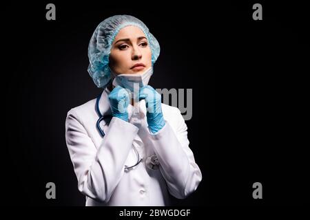 Photo of tired lady doc taking off protective mask after late operation breathing fresh air dream come home wear gloves lab white coat surgical cap Stock Photo