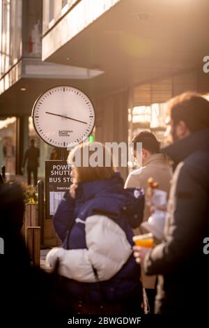 Commuters queue in a shuttle bus line on a sunny winters morning at Circus West Village near Battersea power station redevelopment in Nine Elms London Stock Photo