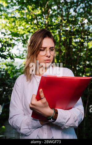 Young female agricultural engineer working in greenhouse. Stock Photo