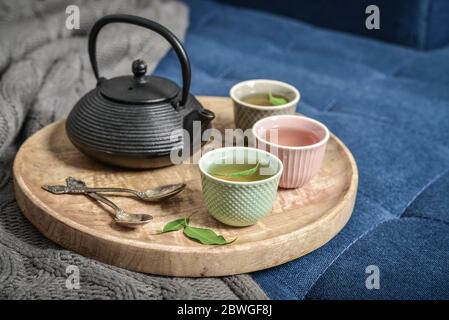 Black iron asian tea set on wooden tray on knitted plaid closeup Stock Photo