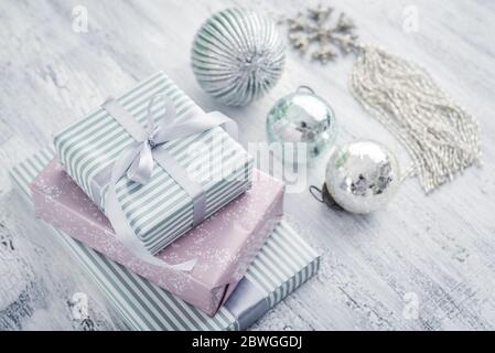 Stack gift boxes with christmas decoration in shape of snowflake on white wooden background Stock Photo